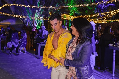 a man in a yellow fringed jacket is dancing with a woman - 