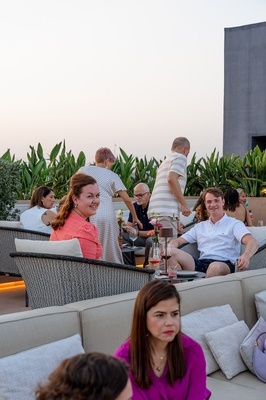 a group of people sitting on a couch with a man standing behind them - 