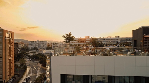 a group of people sitting at tables on a rooftop