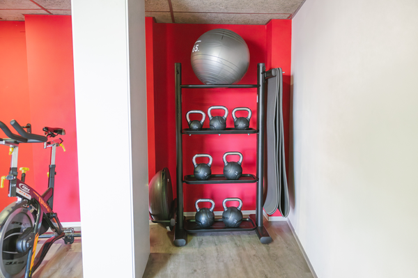 un gimnasio con mancuernas y una cinta de correr