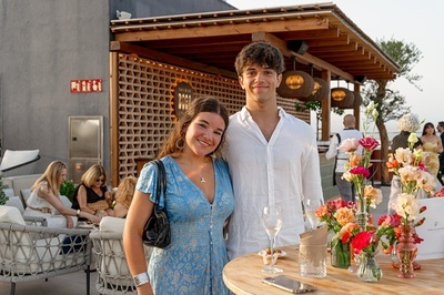 a man and a woman pose for a picture in front of a fire exit sign - 