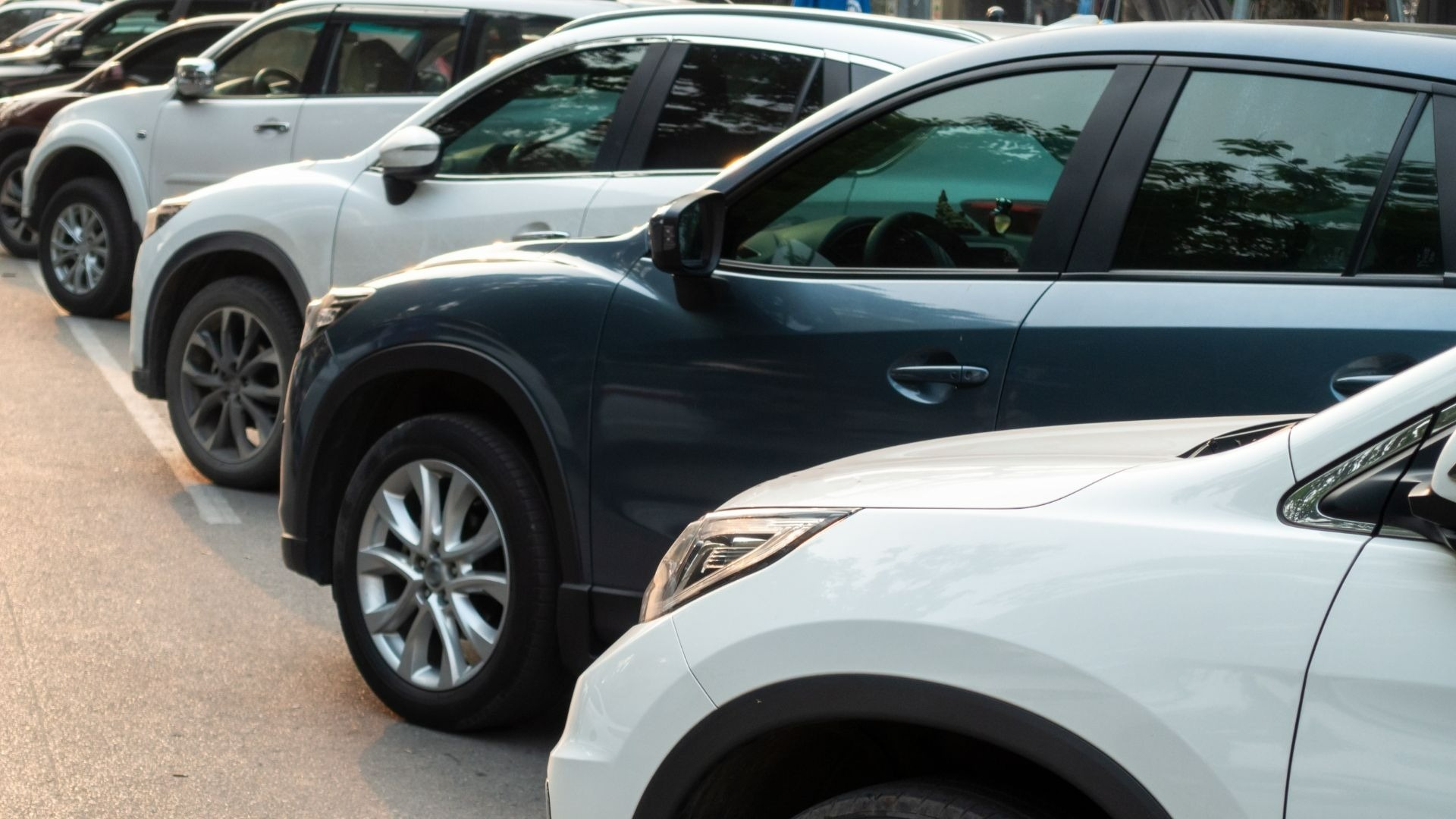 a row of cars are parked on the side of the road