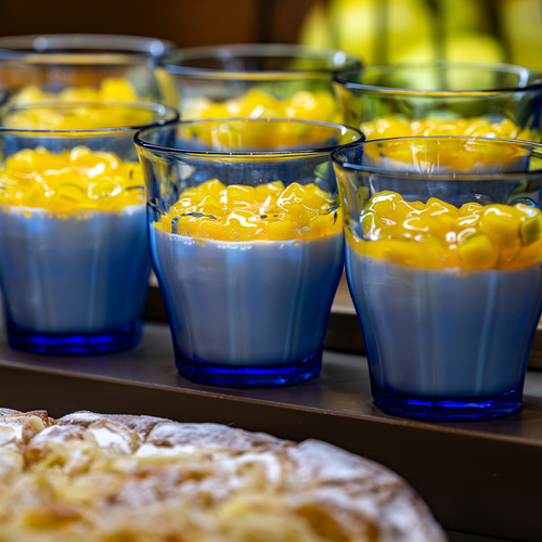 un montón de vasos azules llenos de comida blanca y amarilla