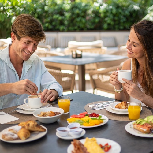 a man and a woman are sitting at a table eating breakfast