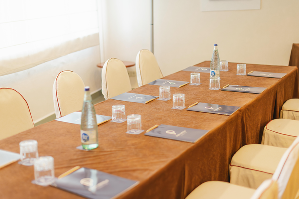 una sala de conferencias con mesas y sillas y una pantalla