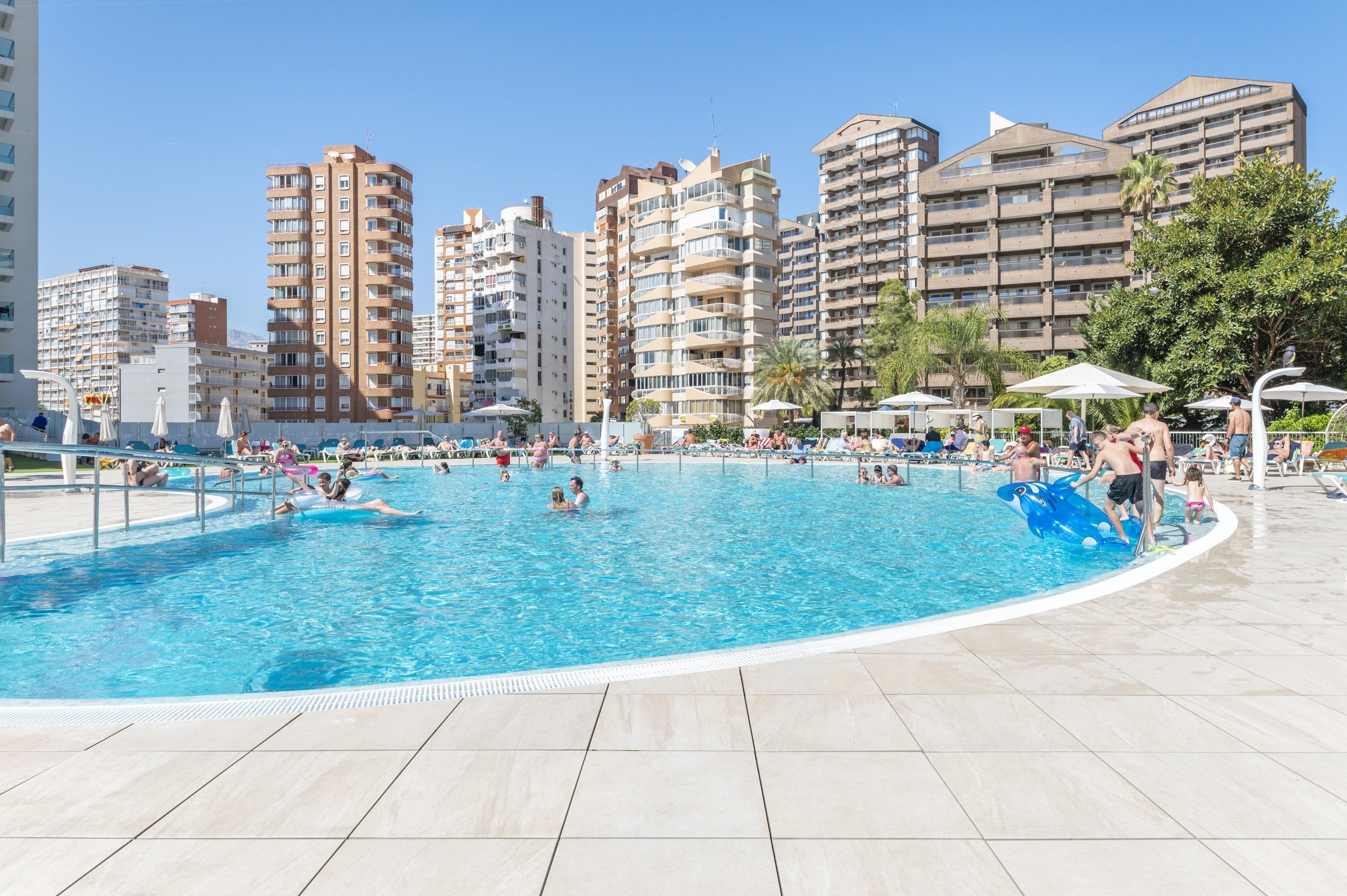 a large swimming pool surrounded by tall buildings on a sunny day