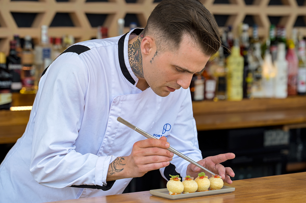 un grupo de personas están sentadas en sillas y mesas en un patio al aire libre