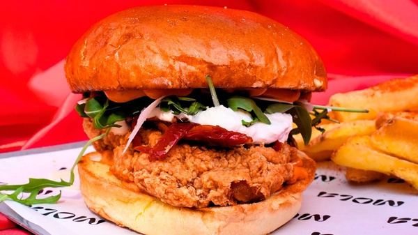 una hamburguesa y papas fritas están envueltos en papel mola