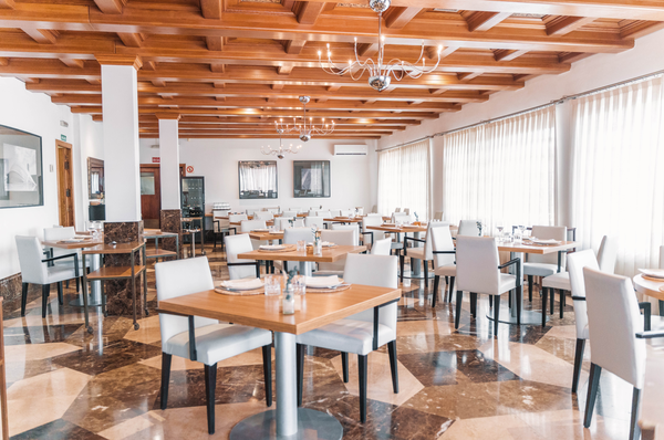 un restaurante lleno de mesas y sillas con un suelo de mármol