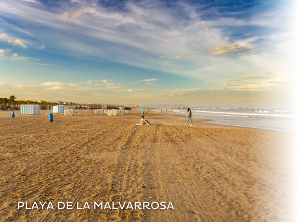 una pasarela de madera conduce a la playa al atardecer