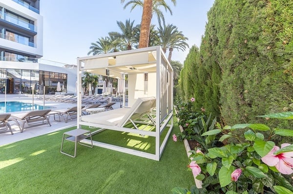 una piscina rodeada de sillas y sombrillas en un hotel