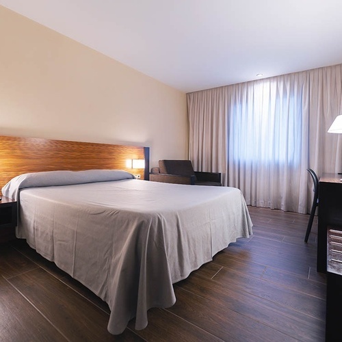 una habitación de hotel con una cama y una mesa