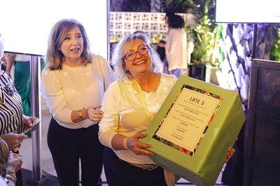 dos mujeres sostienen una caja verde que dice lote 3 - 