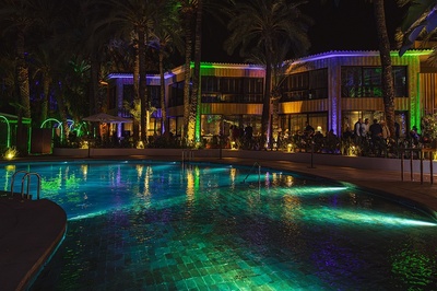 la piscina está iluminada con luces verdes y moradas - 