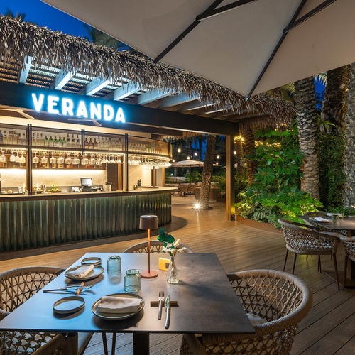 a restaurant with tables and chairs under a sign that says veranda
