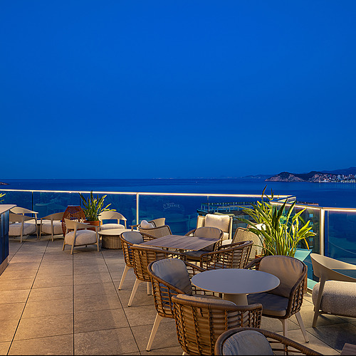 Terraza de hotel con vista al mar y mobiliario moderno. Port Hotels: Corporativa