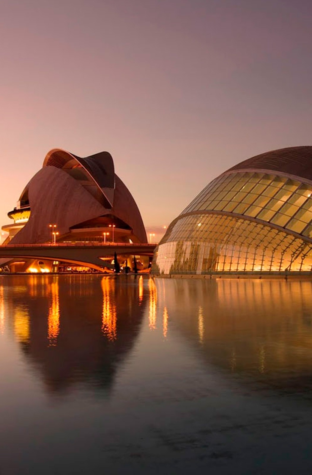 Valencia: Ciudad de las Artes y las Ciencias al atardecer, edificios futuristas reflejados en el agua.