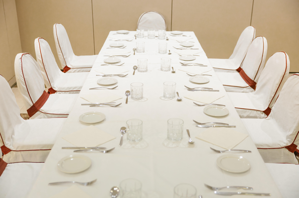 una sala de conferencias con mesas y sillas y una pantalla