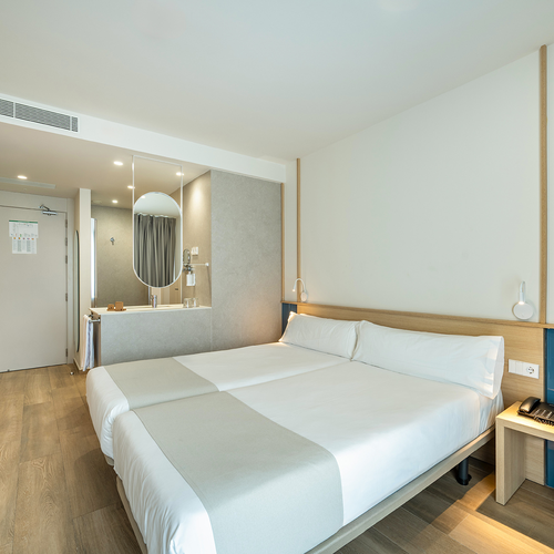 una habitación de hotel con dos camas y un teléfono