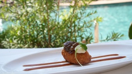 un primer plano de un plato de comida con una piscina en el fondo