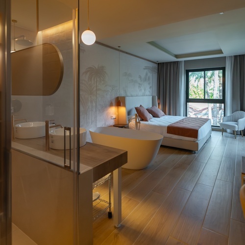 a hotel room with a bathtub and two sinks