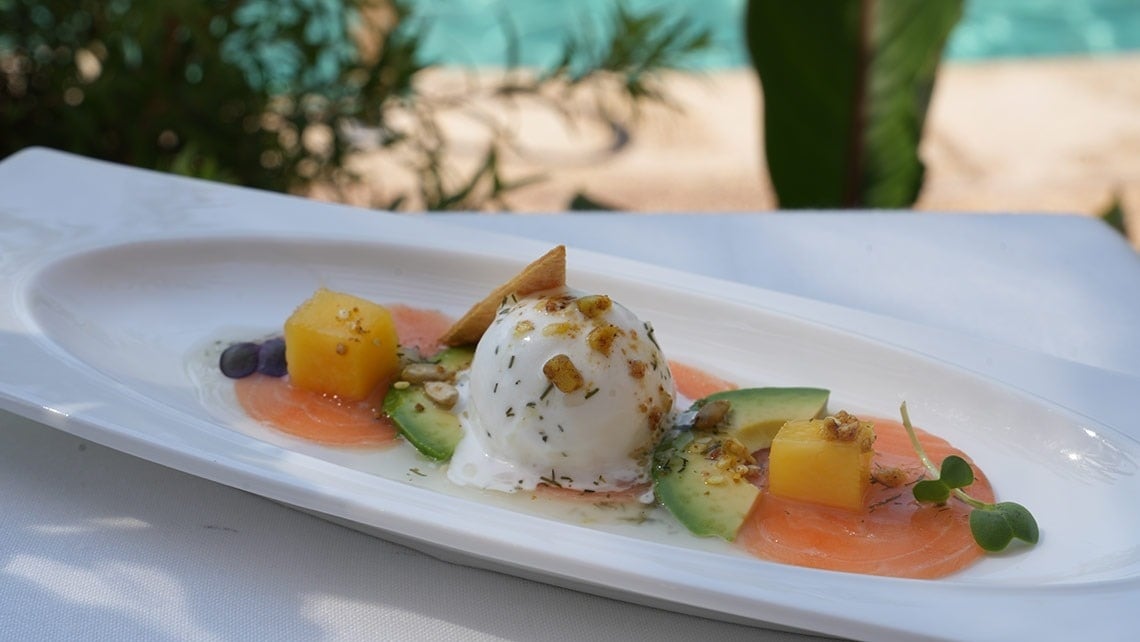 un plato de comida con aguacate y melón sobre una mesa