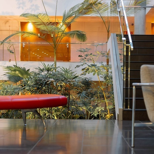 un banco rojo está al lado de una escalera en un edificio