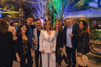 a group of people posing for a picture in front of palm trees - 