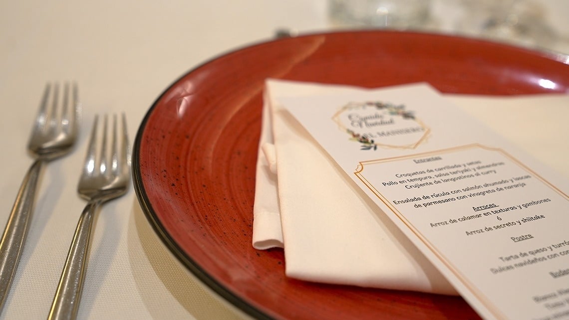 a red plate with silverware and a menu on it