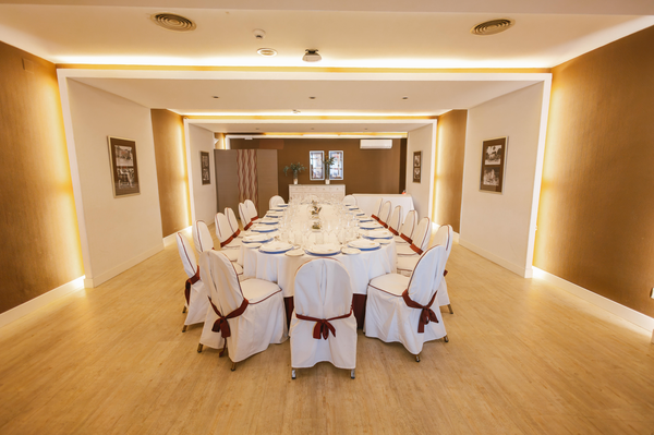 una sala de conferencias con mesas y sillas y una pantalla