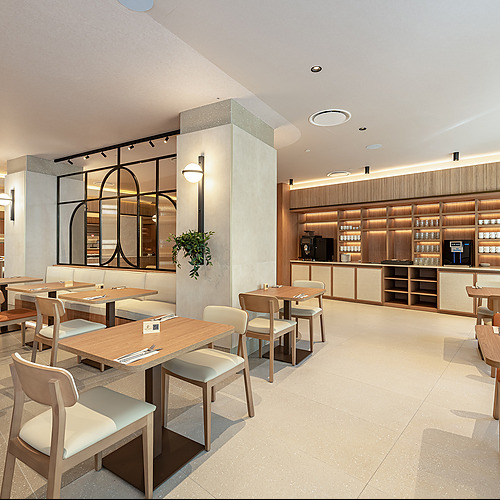 Elegante comedor de hotel con mesas de madera y sillas modernas. Port Hotels: Corporativa