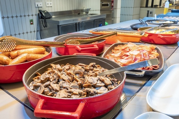 una bandeja de brócoli se sienta en una mesa junto a otros platos de comida