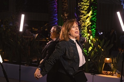 a woman in a black jacket is standing next to another woman - 