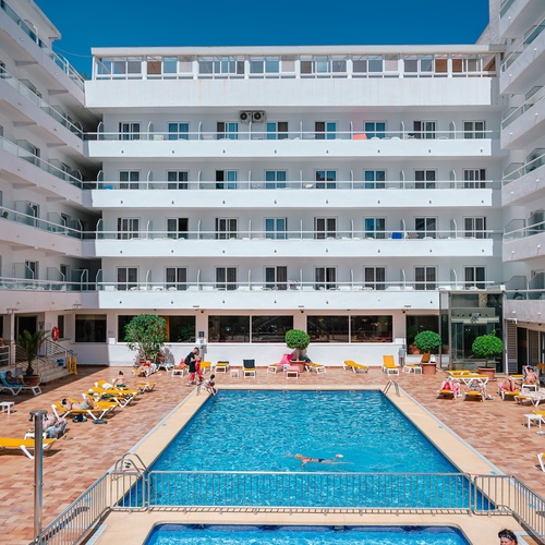 a large white building with a swimming pool in front of it