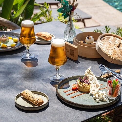 a table with plates of food and glasses of beer