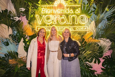 three women pose in front of a sign that says bienvenido al verano - 