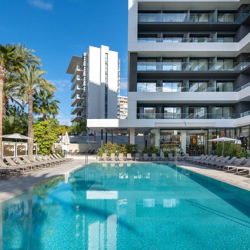 una gran piscina rodeada de sillas y sombrillas en un hotel