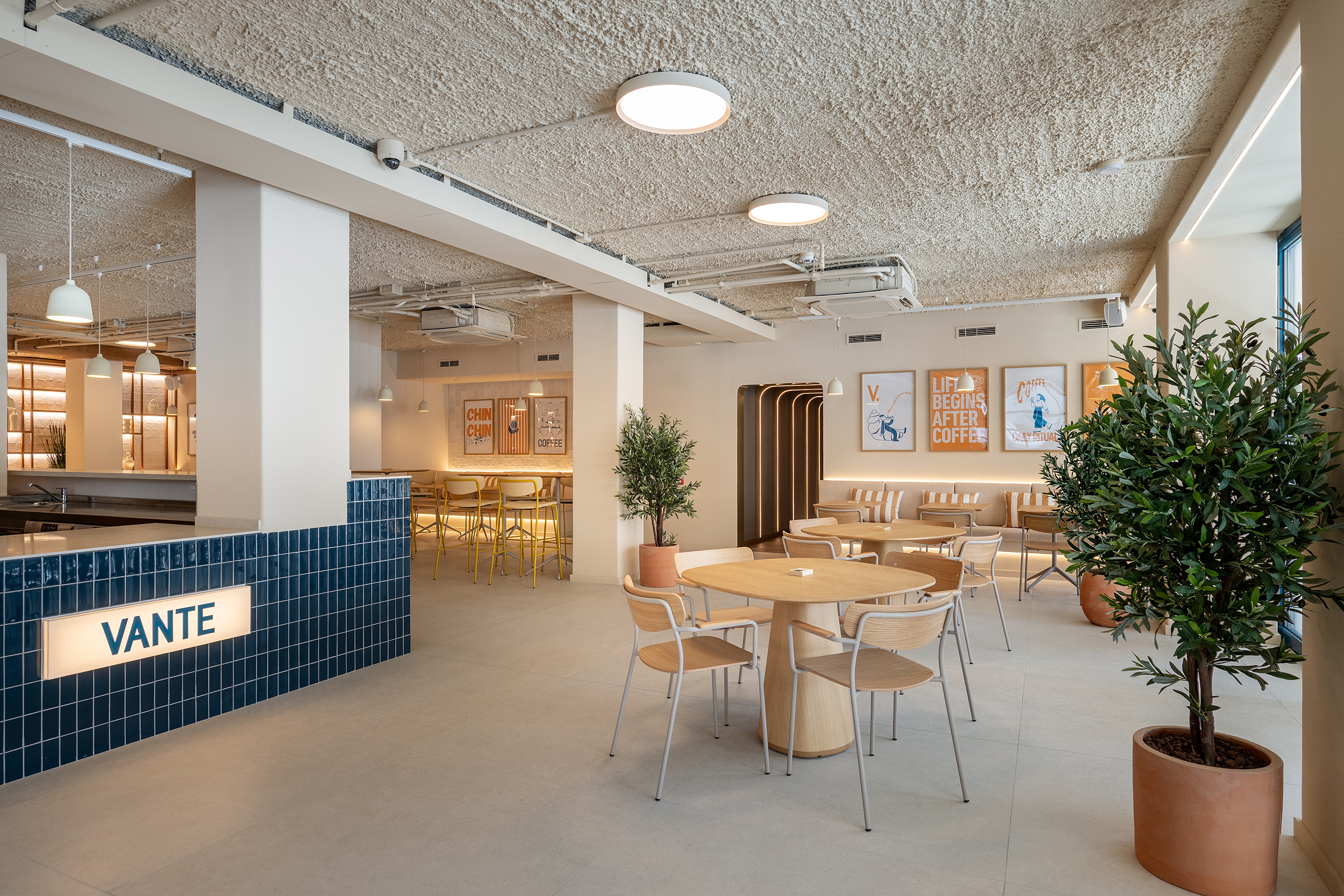 Modern cafe interior with stylish seating, decor, and Vante branding Port Hotels: Corporativa.
