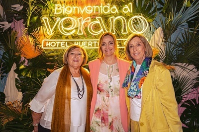 three women pose in front of a sign that says bienvenido al verano - 
