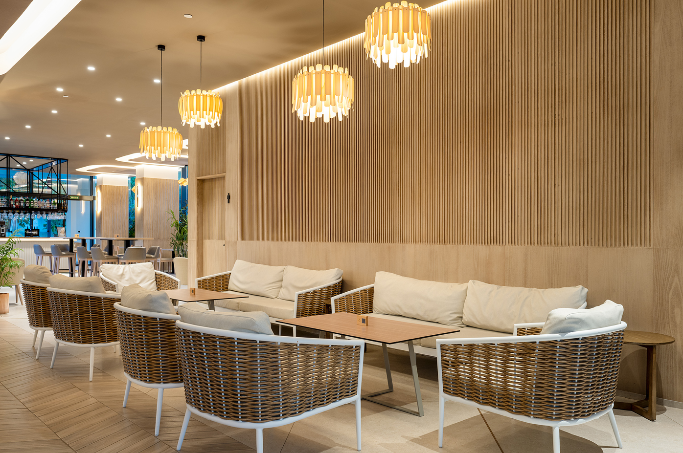 una sala de estar con sofás y sillas y lámparas colgantes