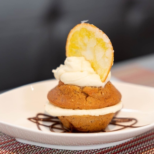 una magdalena con glaseado y una rodaja de naranja encima