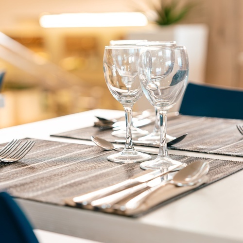 dos copas de vino están sobre una mesa con cubiertos