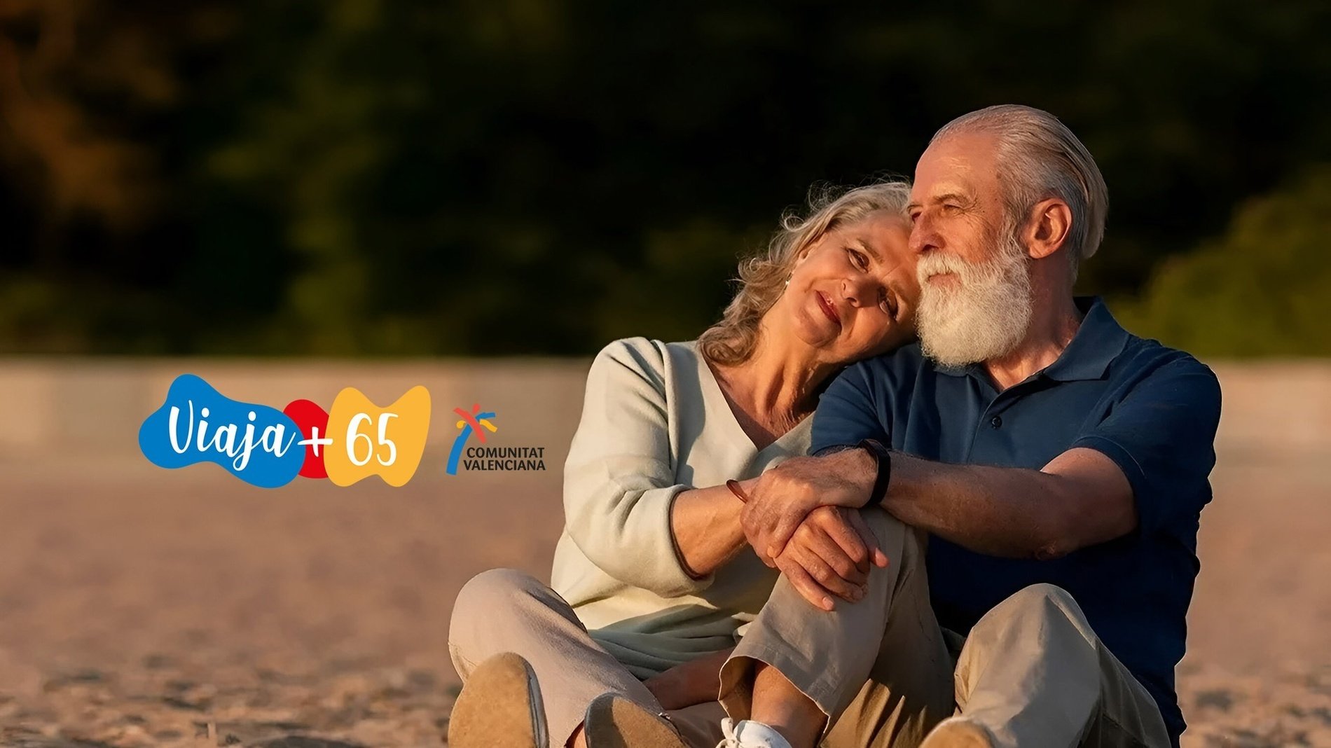 un hombre y una mujer están sentados en la playa con un cartel que dice viaja + 65