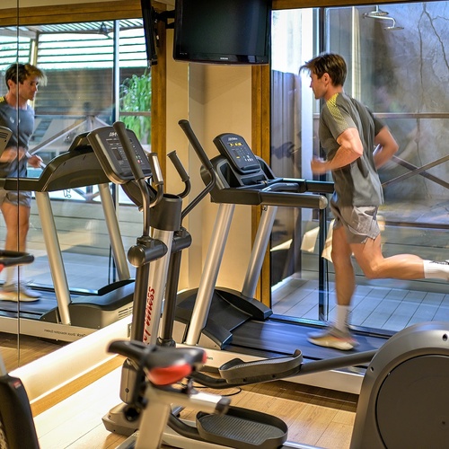 a man is running on a treadmill in a gym