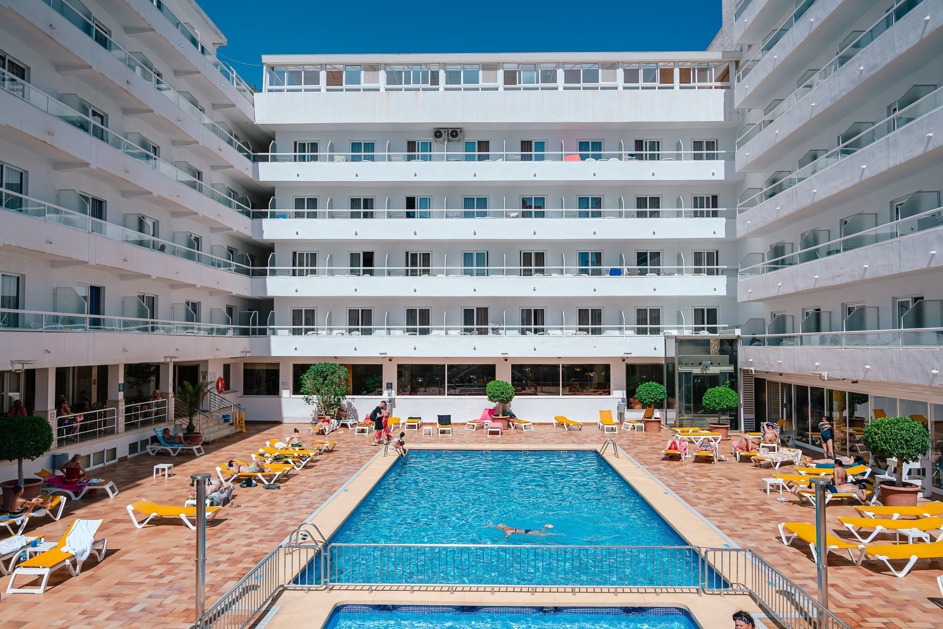 a large white building with a swimming pool in front of it