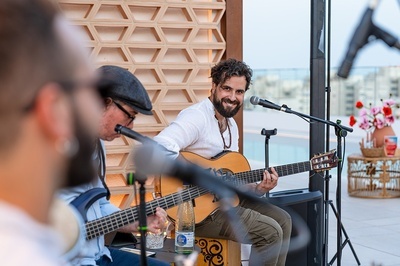 un hombre toca la guitarra frente a un micrófono y una botella de agua de la sierra - 