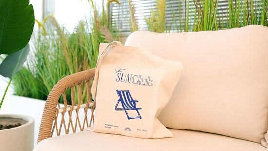 una bolsa que dice el club del sol está sentada en un sofá