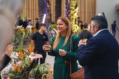 a woman in a green dress is holding a glass of beer - 