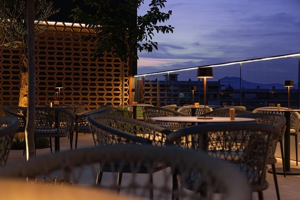 a group of people sitting at tables on a rooftop