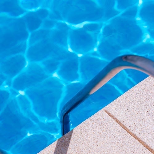 una escalera que conduce a una piscina con agua azul